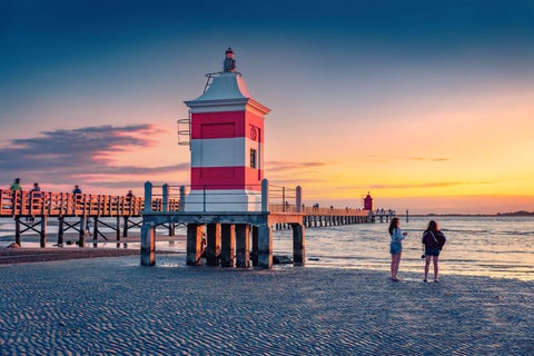 Rustic bridge to the beach alongside a lighthouse in Lignano, Italy