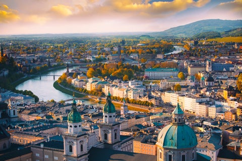 An aerial view of Salzburg City Center with its historic buildings and Salzach River in the Fall