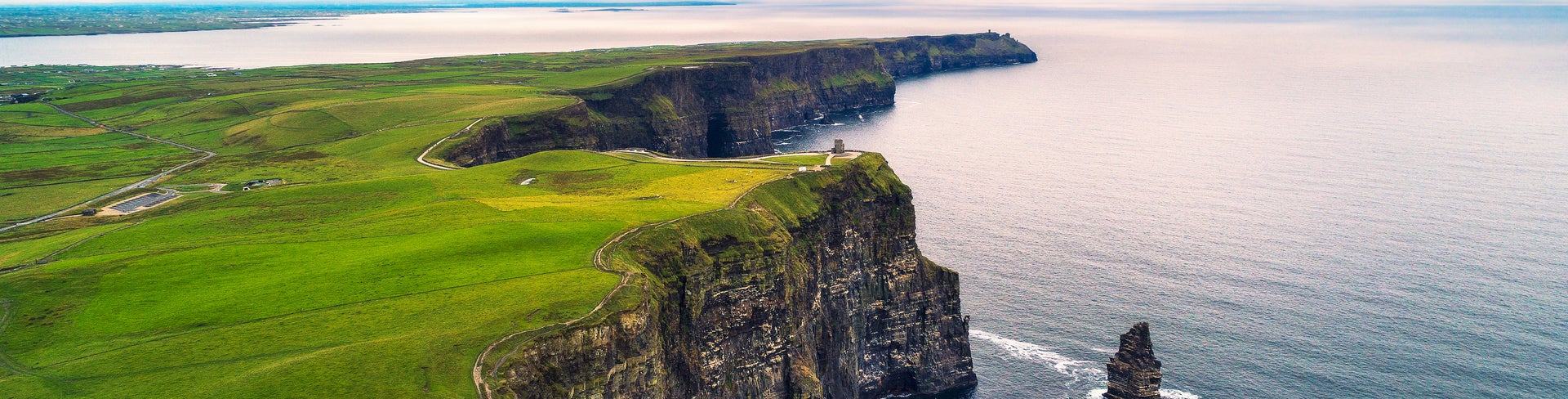 Aerial view of the Cliffs of Moher in Ireland, beautiful blue ocean and green grassy fields