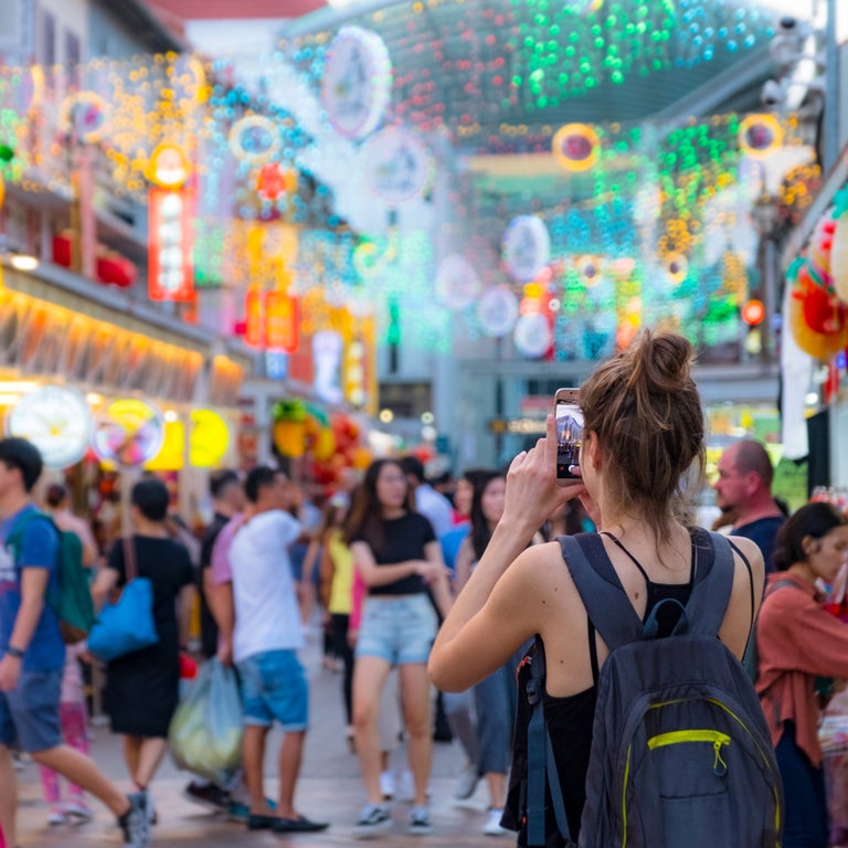 Tourist in Singapore photographing classic decorative architecture in the city center
