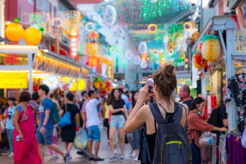 Tourist in Singapore photographing classic decorative architecture in the city center