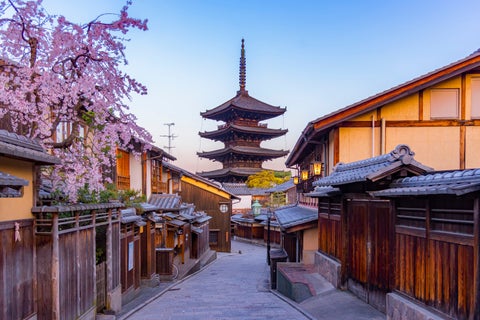 An alley view of Ninenzaka with its traditional wooden machiya houses lining a gently sloping stone-paved path in in Kyoto, Japan