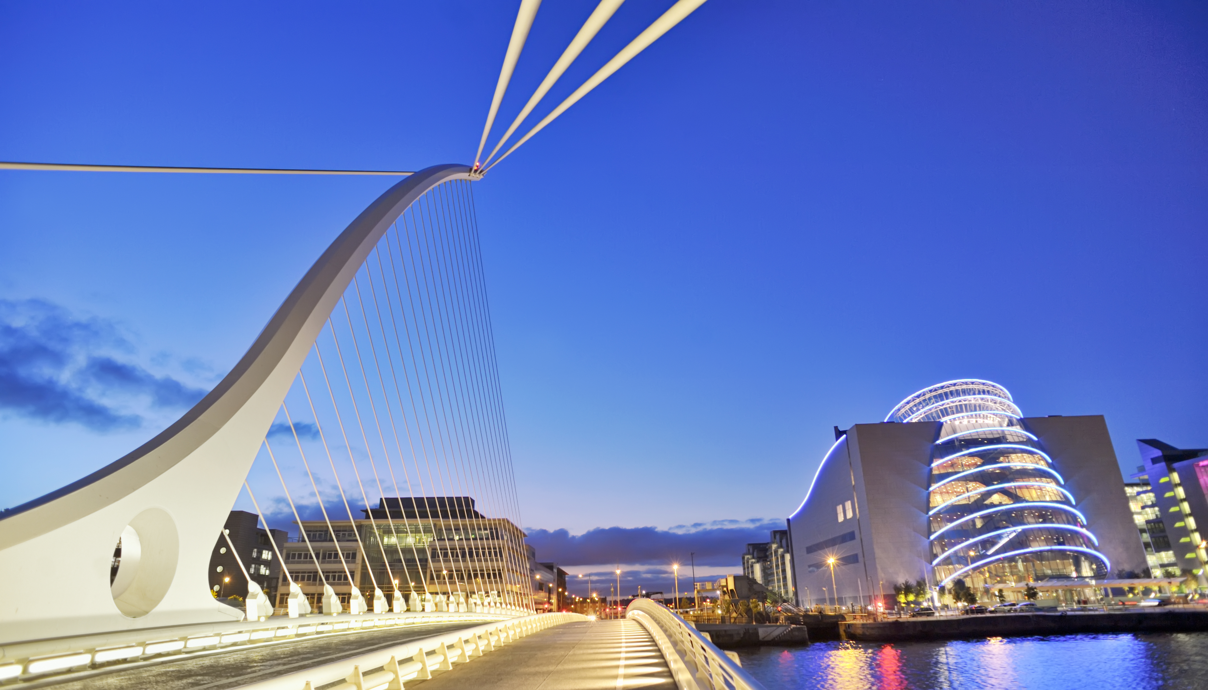 Samuel Beckett Bridge in Dublin at night with city lights reflecting on the River Liffey