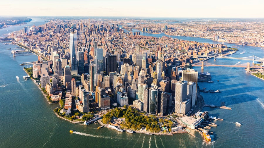Aerial view of Lower Manhattan, New York City, surrounded by the Hudson River and East River, with boats sailing near the Financial District