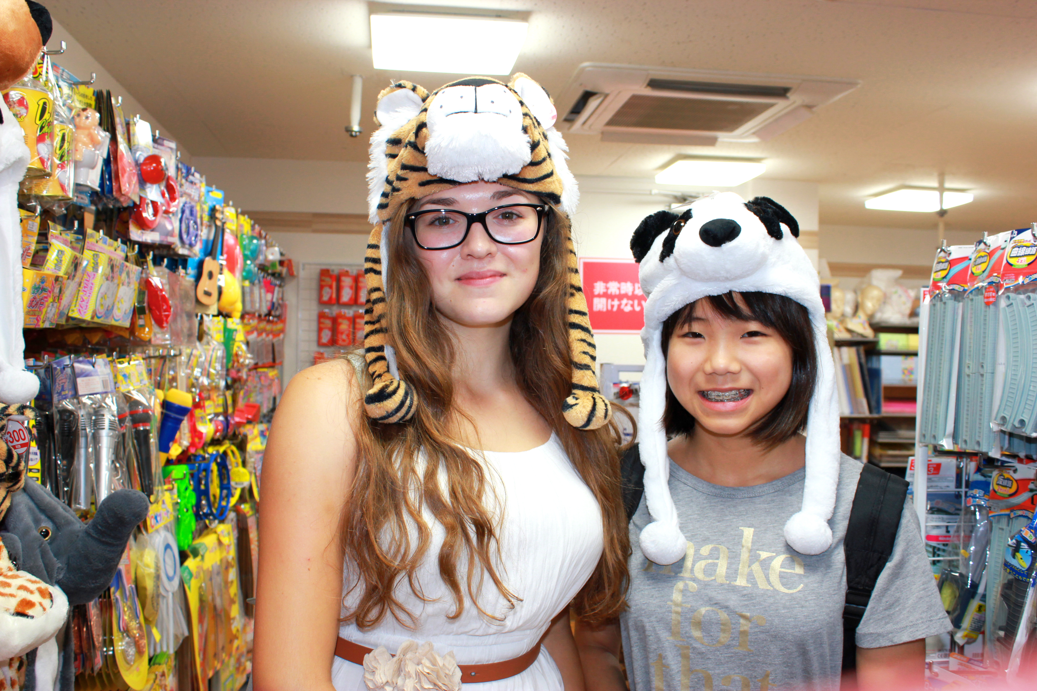 Two students at a store in Kobe wearing funny hats