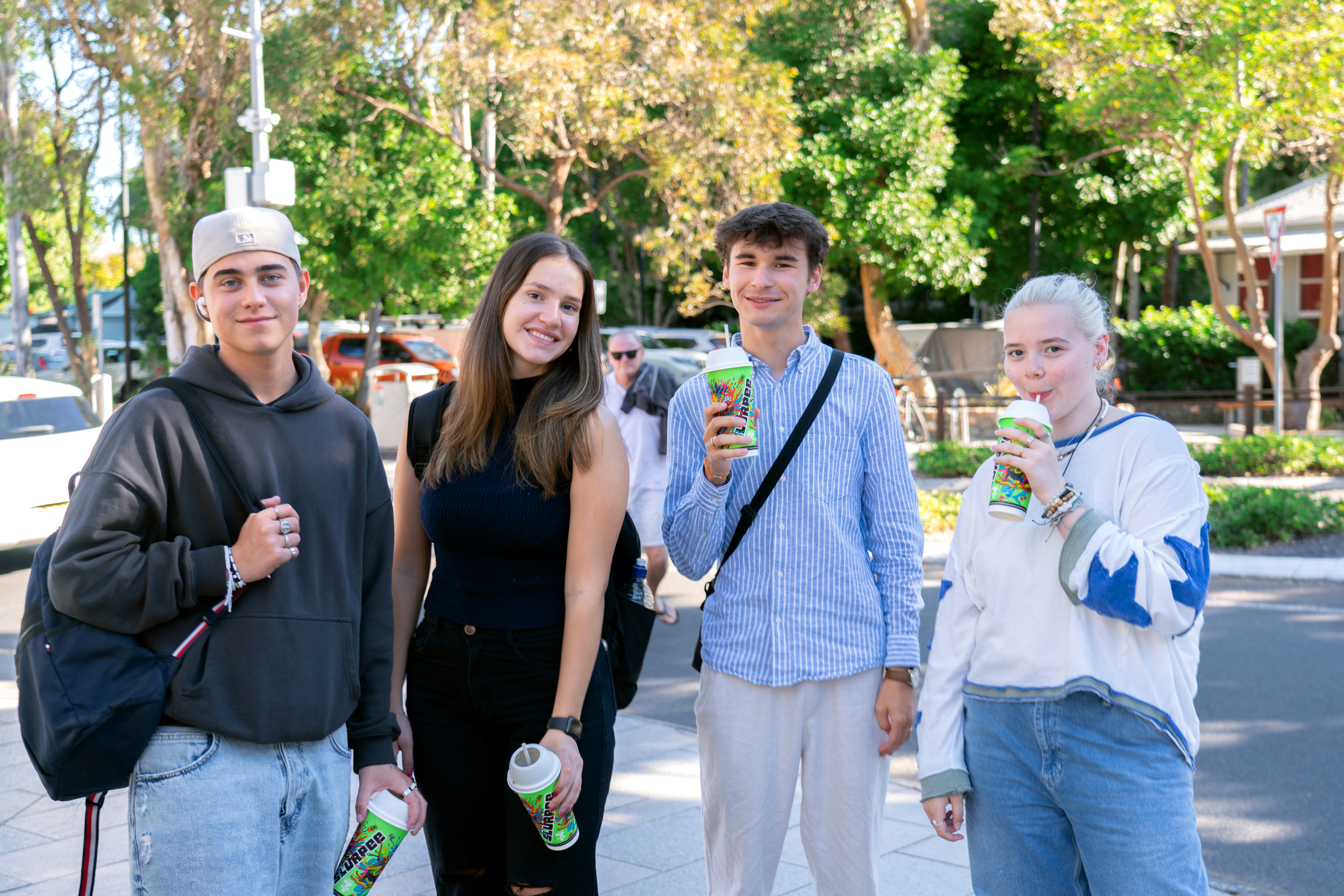 Four students having a drink on the street