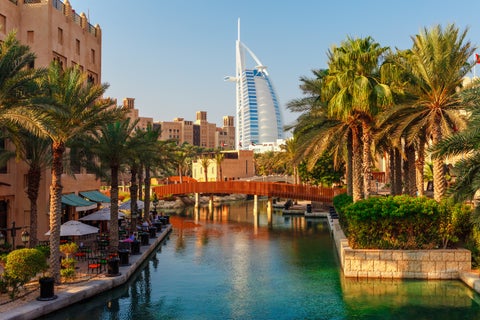 View from the river with a small red bridge leading to the Burj Al Arab, one of Dubai’s most iconic buildings, United Arab Emirates