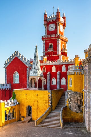 Colourful Pena Palace in Sintra, Portugal, perched on a hilltop with romantic architecture and forested surroundings