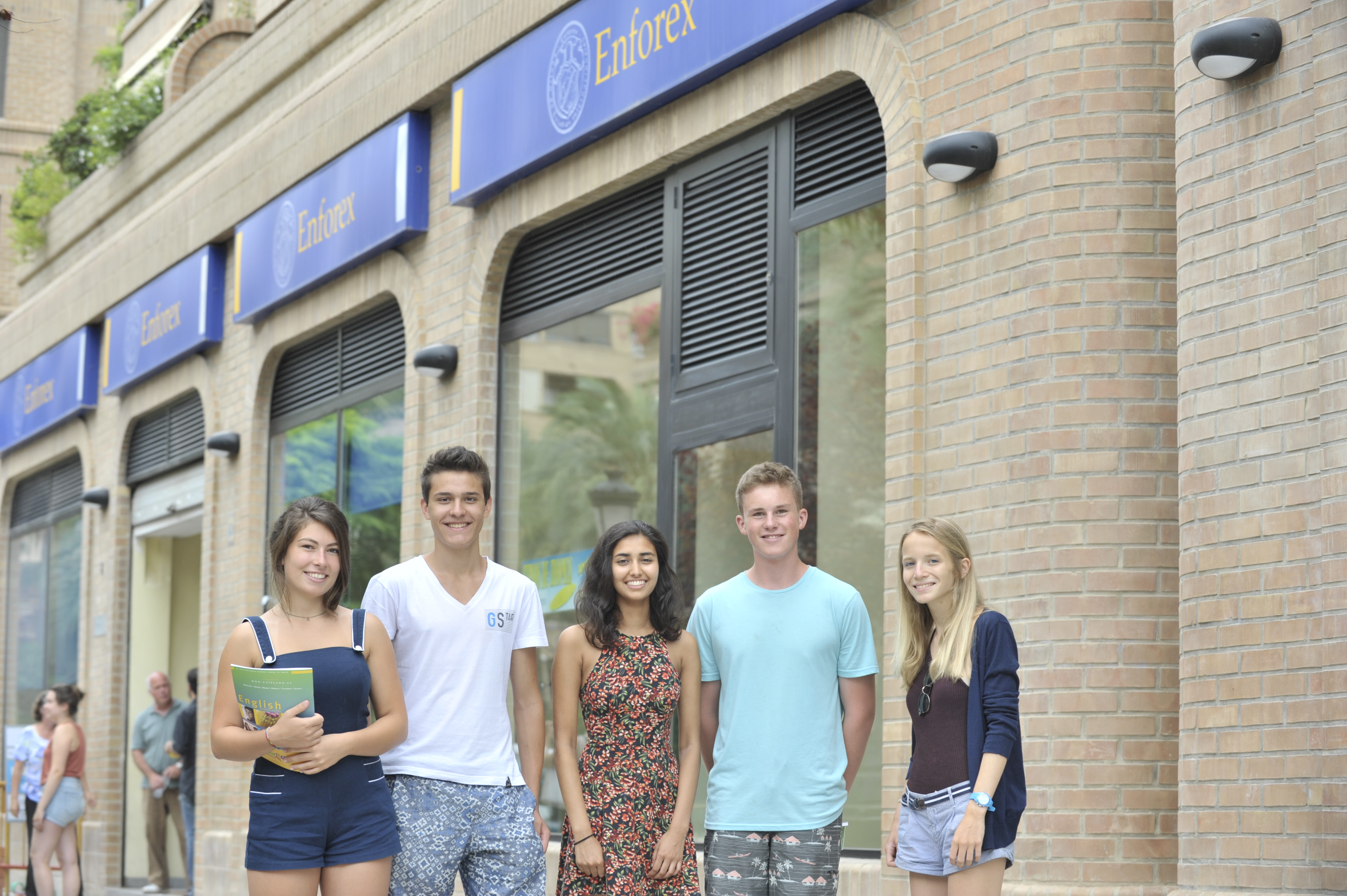 A group of students standing in front of the school
