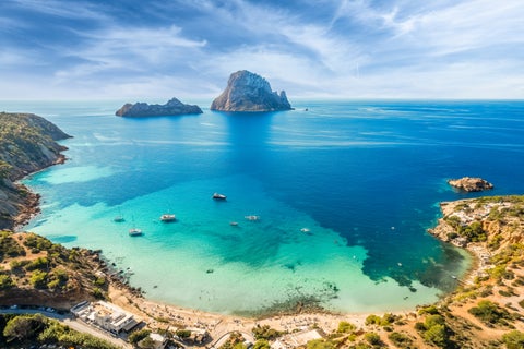 Aerial view of the Mediterranean Sea at Ibiza, Spain, with boats sailing near the coastline and the Tramuntana mountains in the background