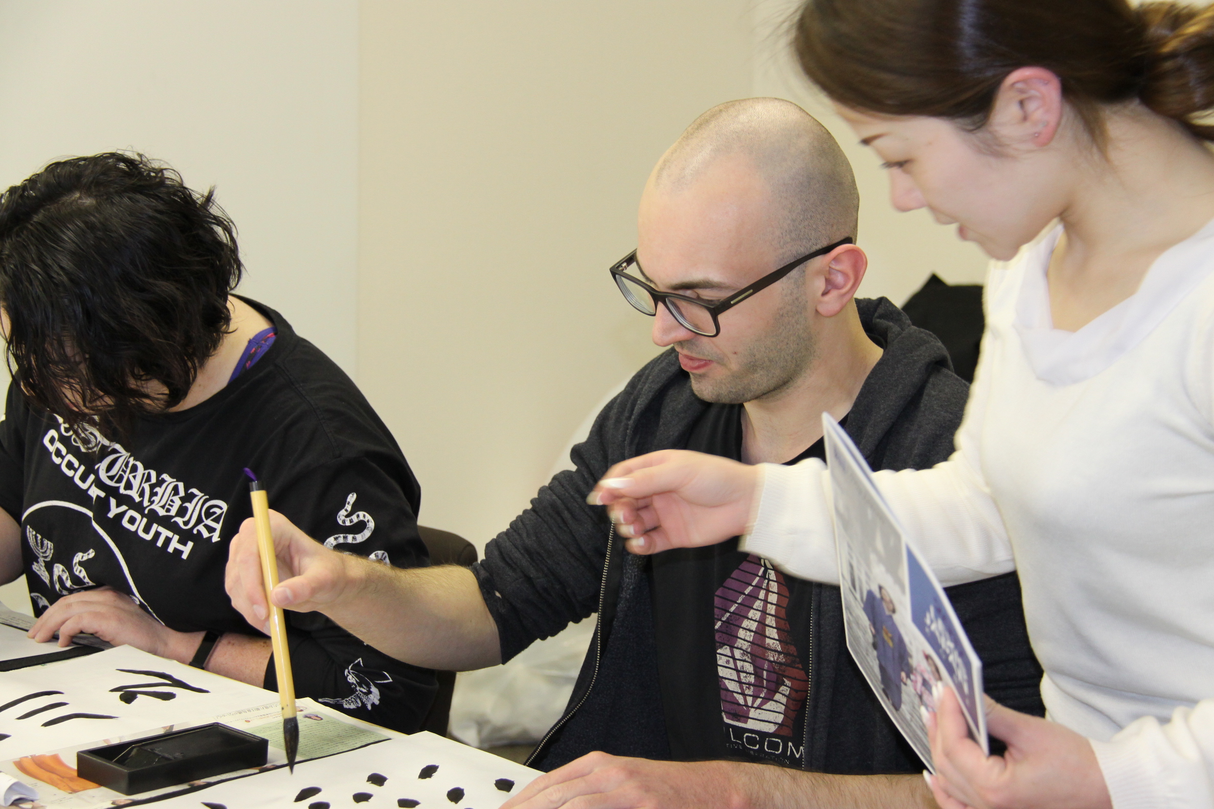 A student working on his calligraphy assignment