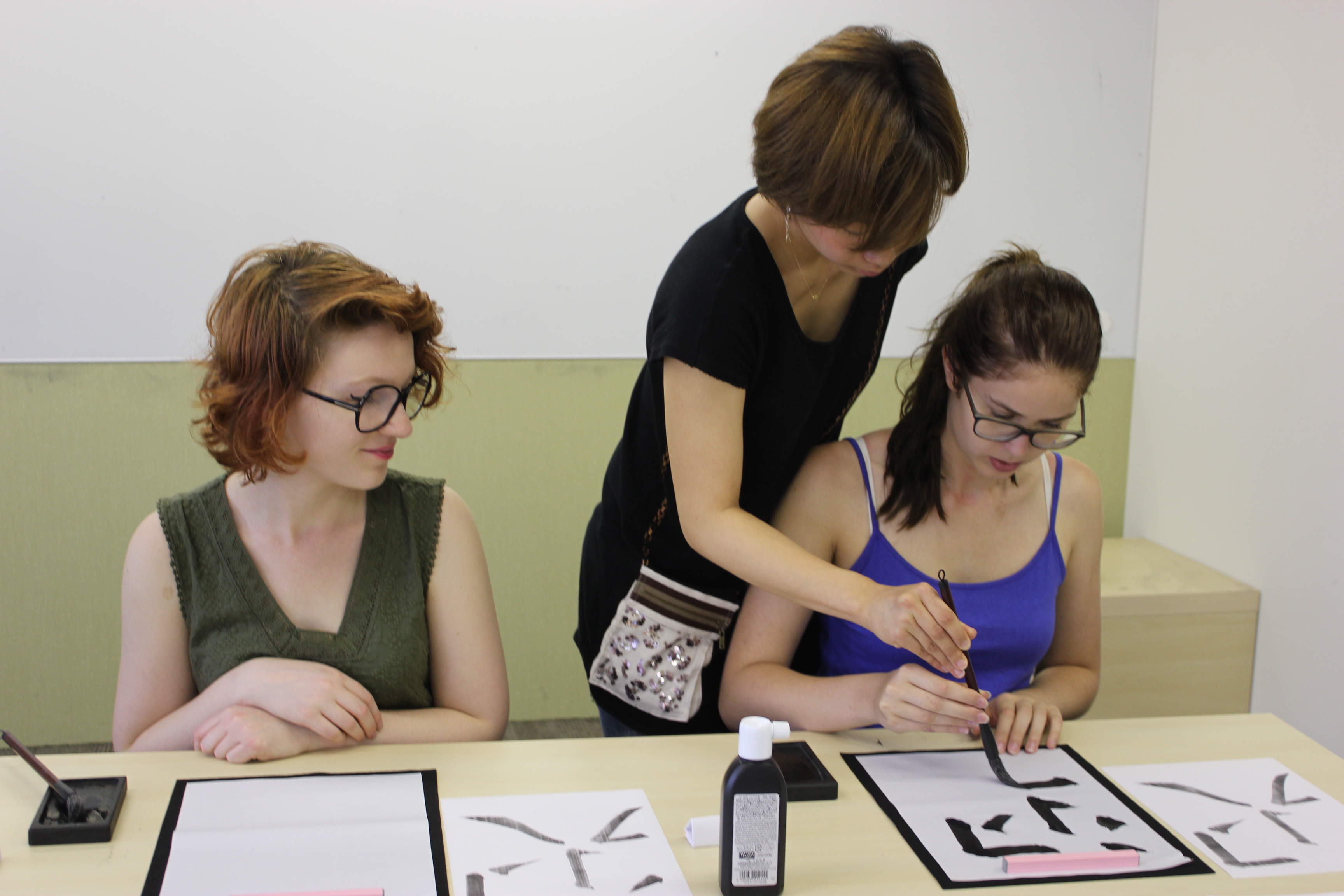 A teacher showing calligraphy to her students