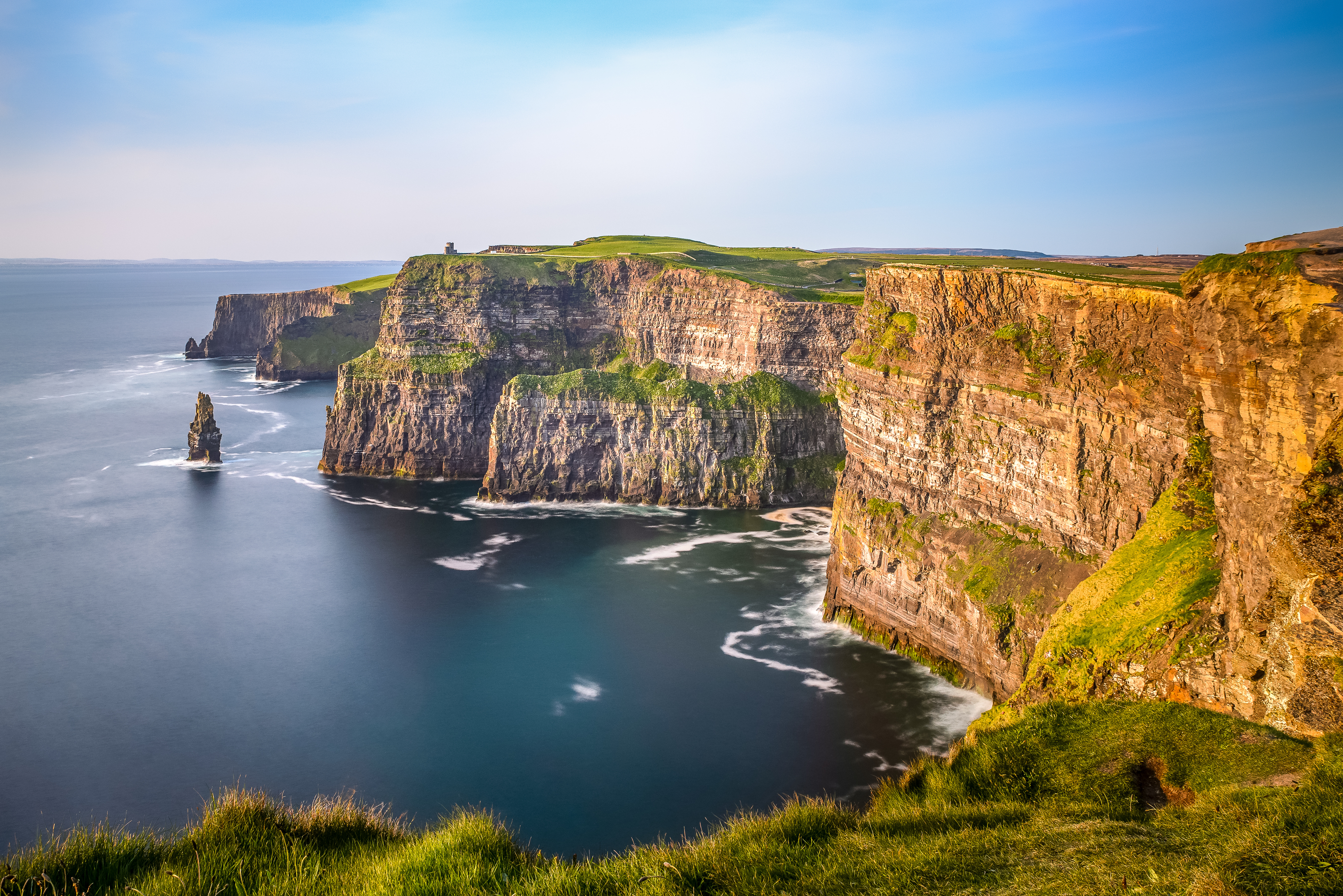 Aerial view of the Cliffs of Moher in Ireland, beautiful blue ocean and green grassy fields
