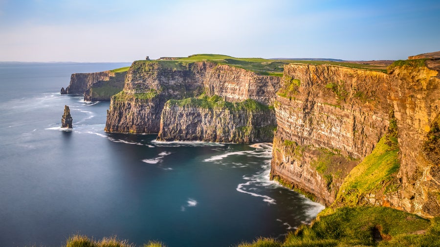 Aerial view of the Cliffs of Moher in Ireland, beautiful blue ocean and green grassy fields