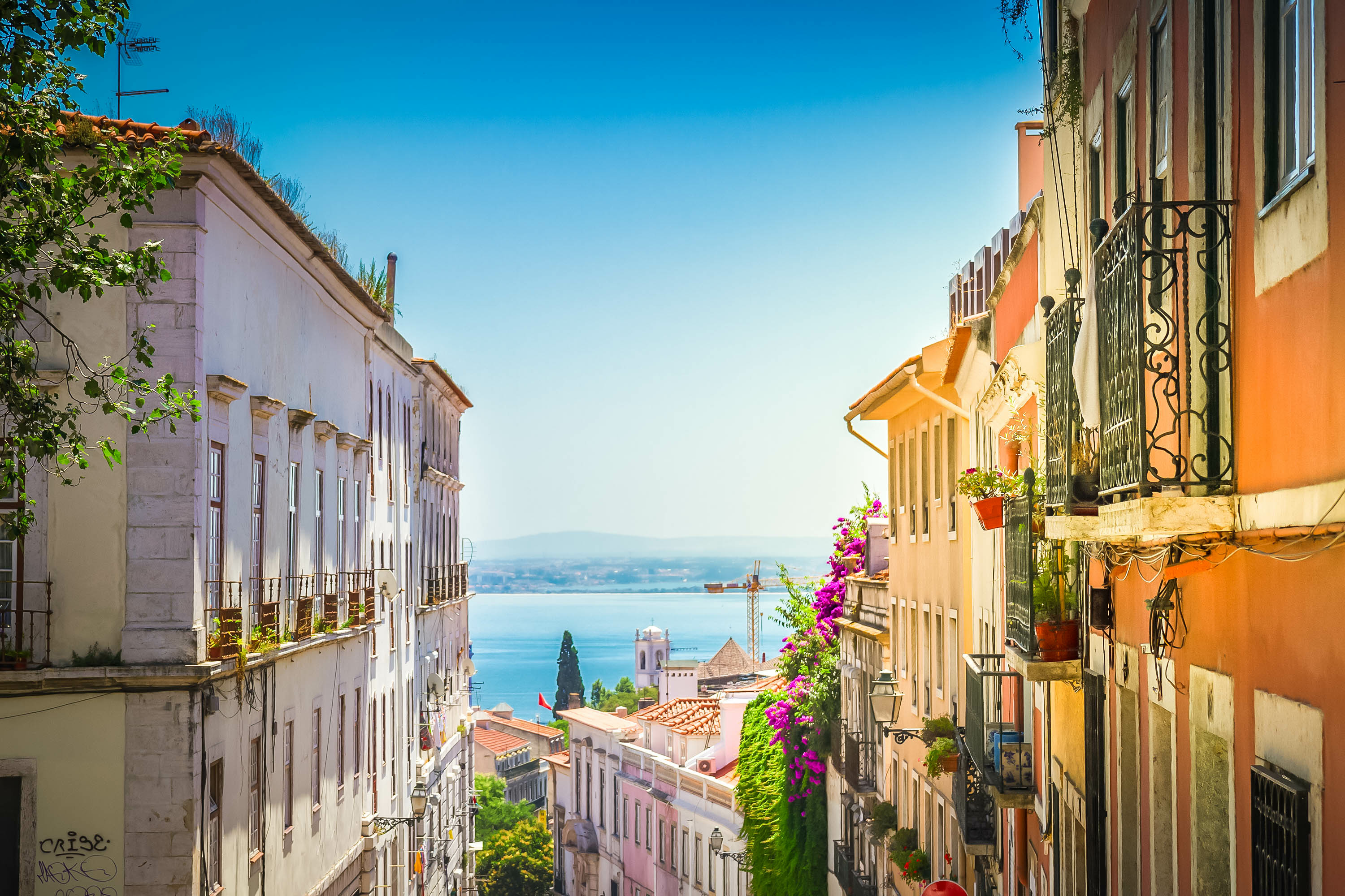 Narrow street in Lisbon old town, Portugal, with cobblestone pavement and colorful traditional Portuguese buildings