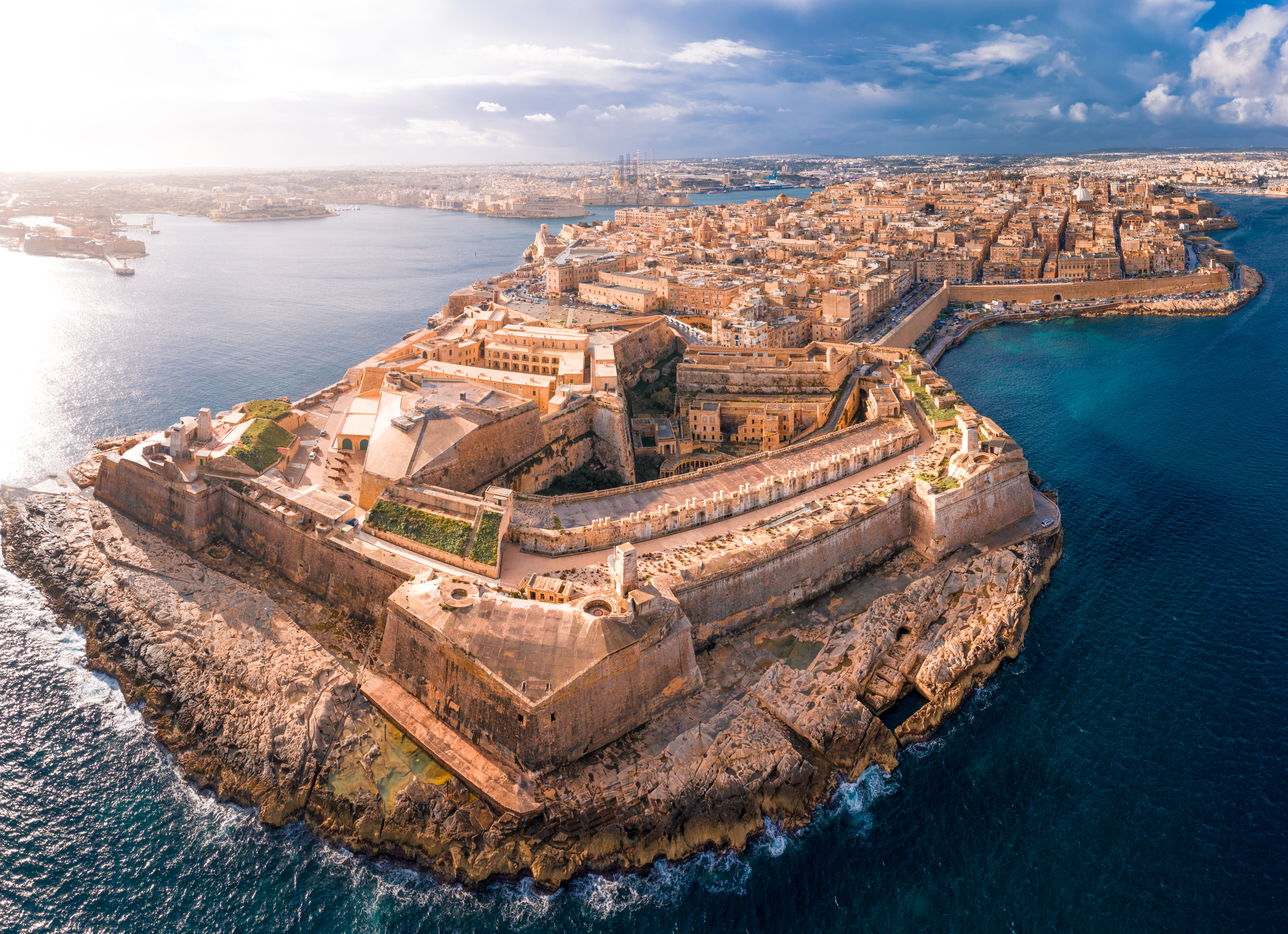 Aerial view of Valletta, Malta surrounded by the Mediterranean Sea, featuring the historic St. John's Co-Cathedral