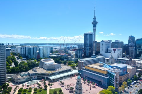 Aerial view of Auckland CBD with Sky Tower, modern high-rises, and Waitematā Harbour in the background