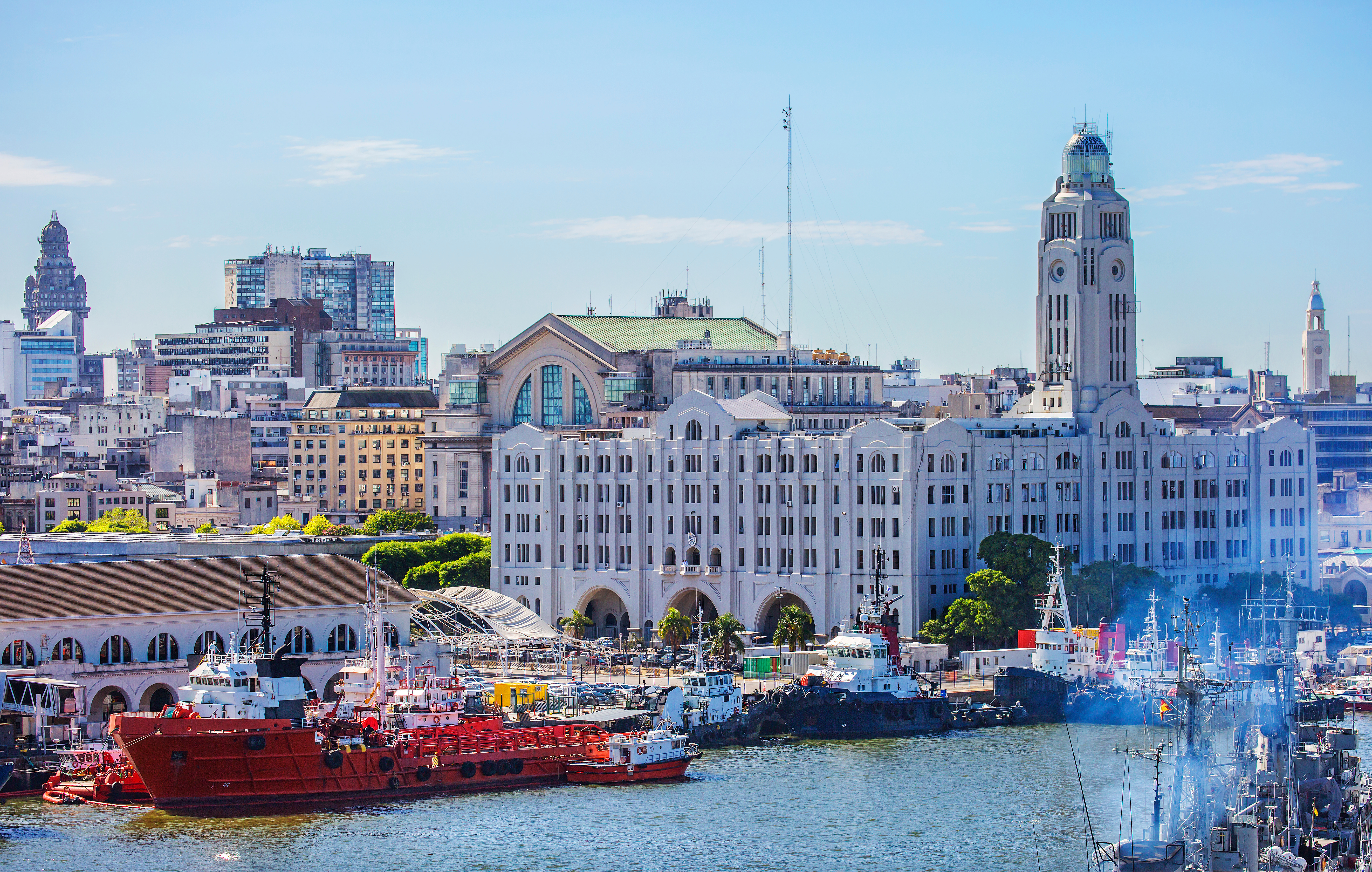 Montevideo city center with Palacio Salvo historic building near the waterfront, boats docked along the shore