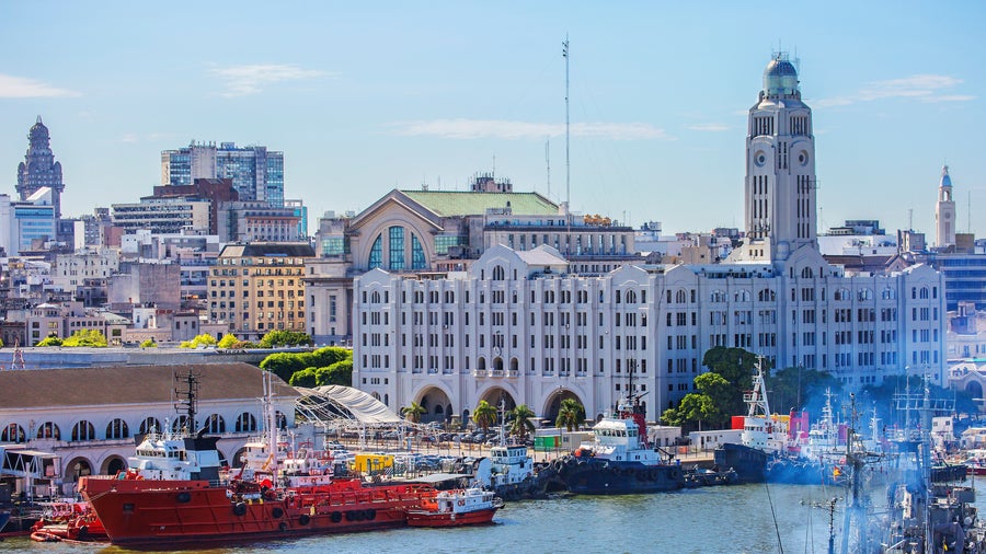 Montevideo city center with Palacio Salvo historic building near the waterfront, boats docked along the shore