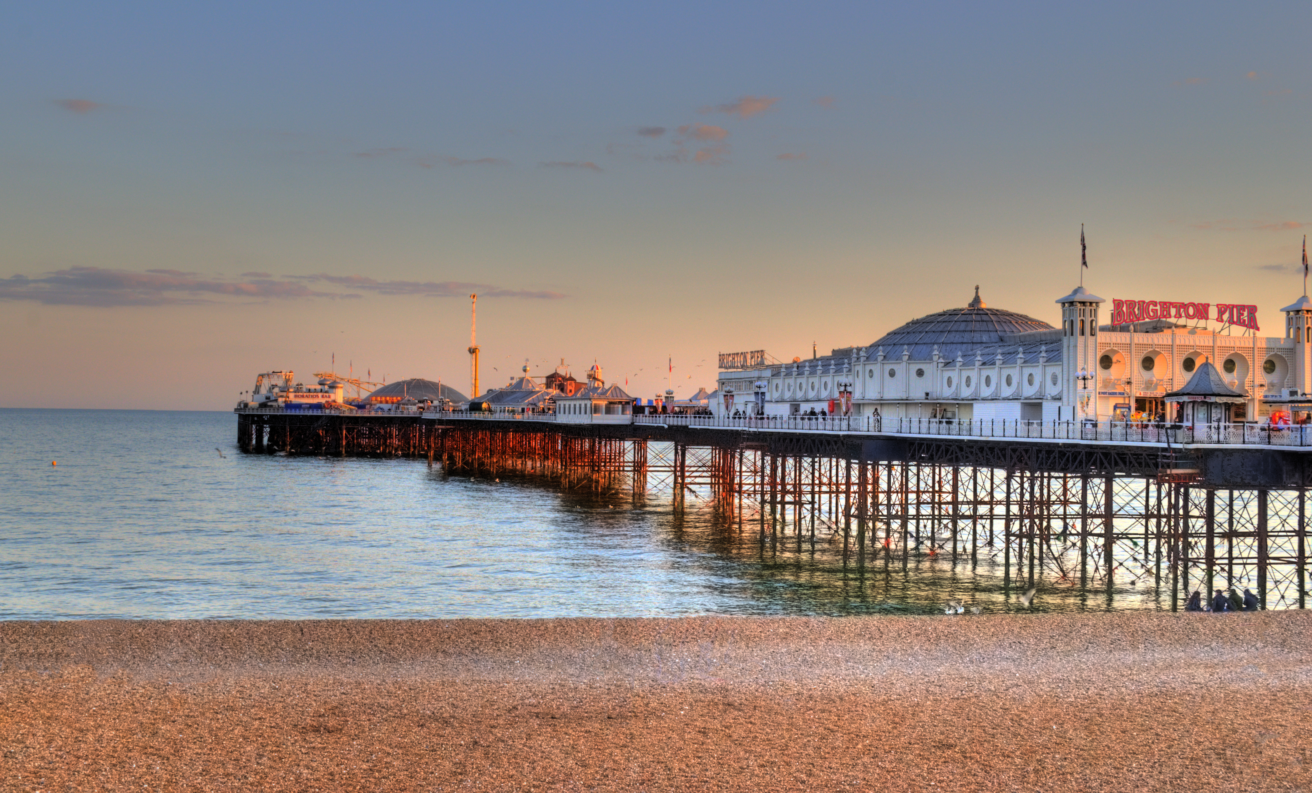 Brighton Pier with amusement rides and colorful lights extending into the English Channel, United Kingdom