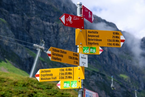 Travel signs in Engelberg, Switzerland, with scenic alpine mountains in the background