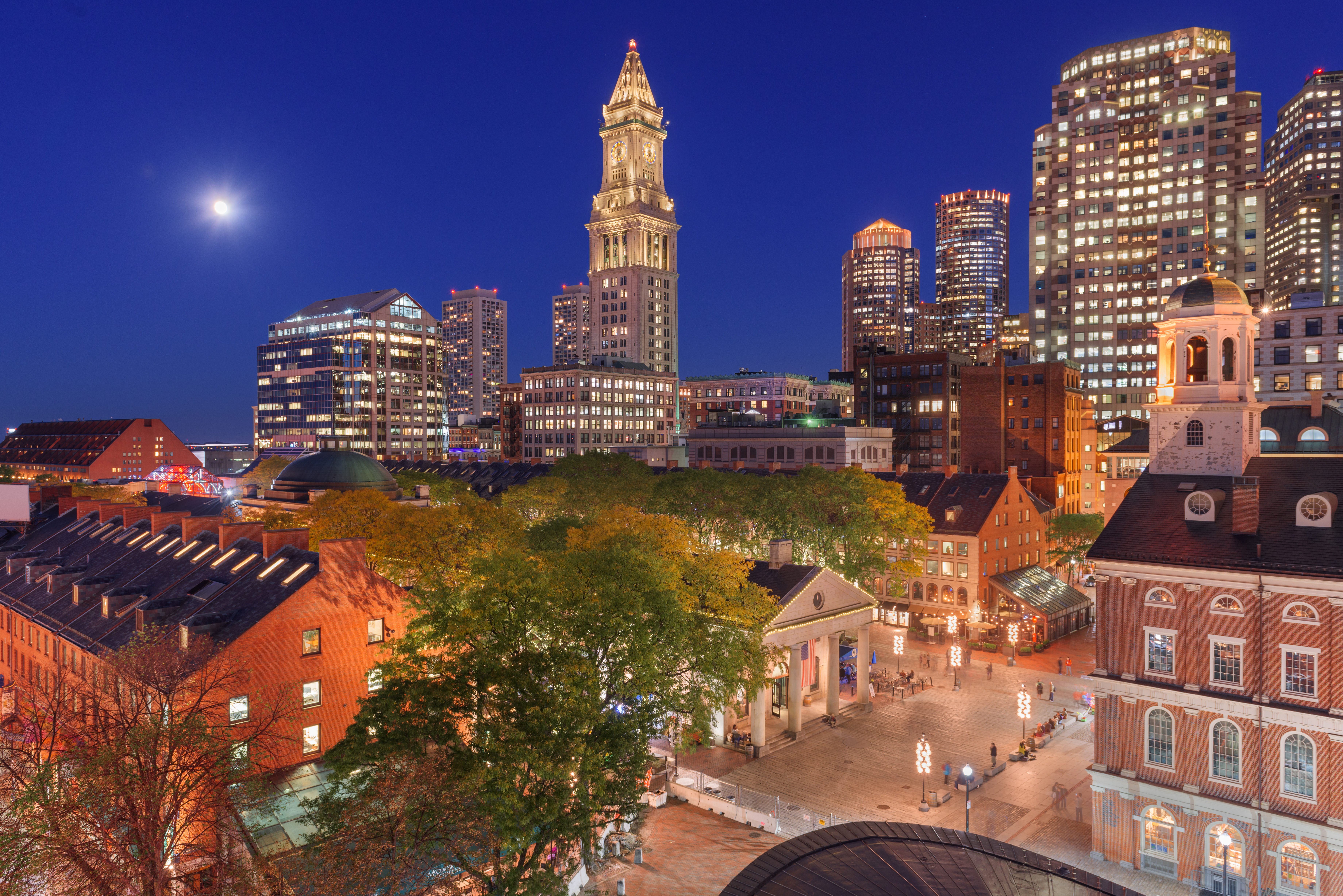 Boston historic city center at night with Custom House Tower and Old State House illuminated under a full moon