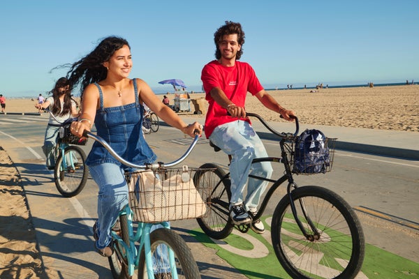 Kaplan International teen students riding bikes along the seaside
