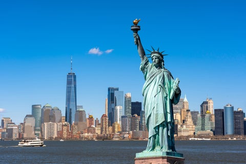 Statue of Liberty in front of New York City skyline and Hudson River, facing Lower Manhattan, USA