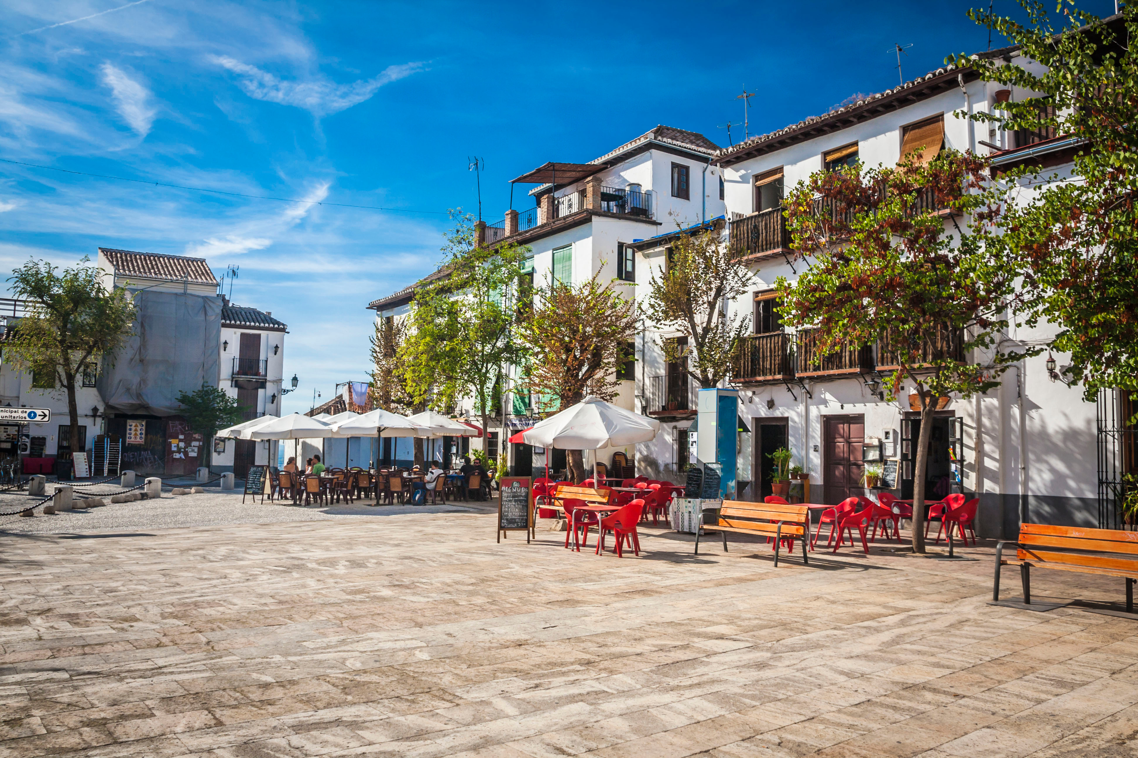 Narrow street in Granada, Spain, with historic houses, cobblestone pavement, and traditional Andalusian architectural details