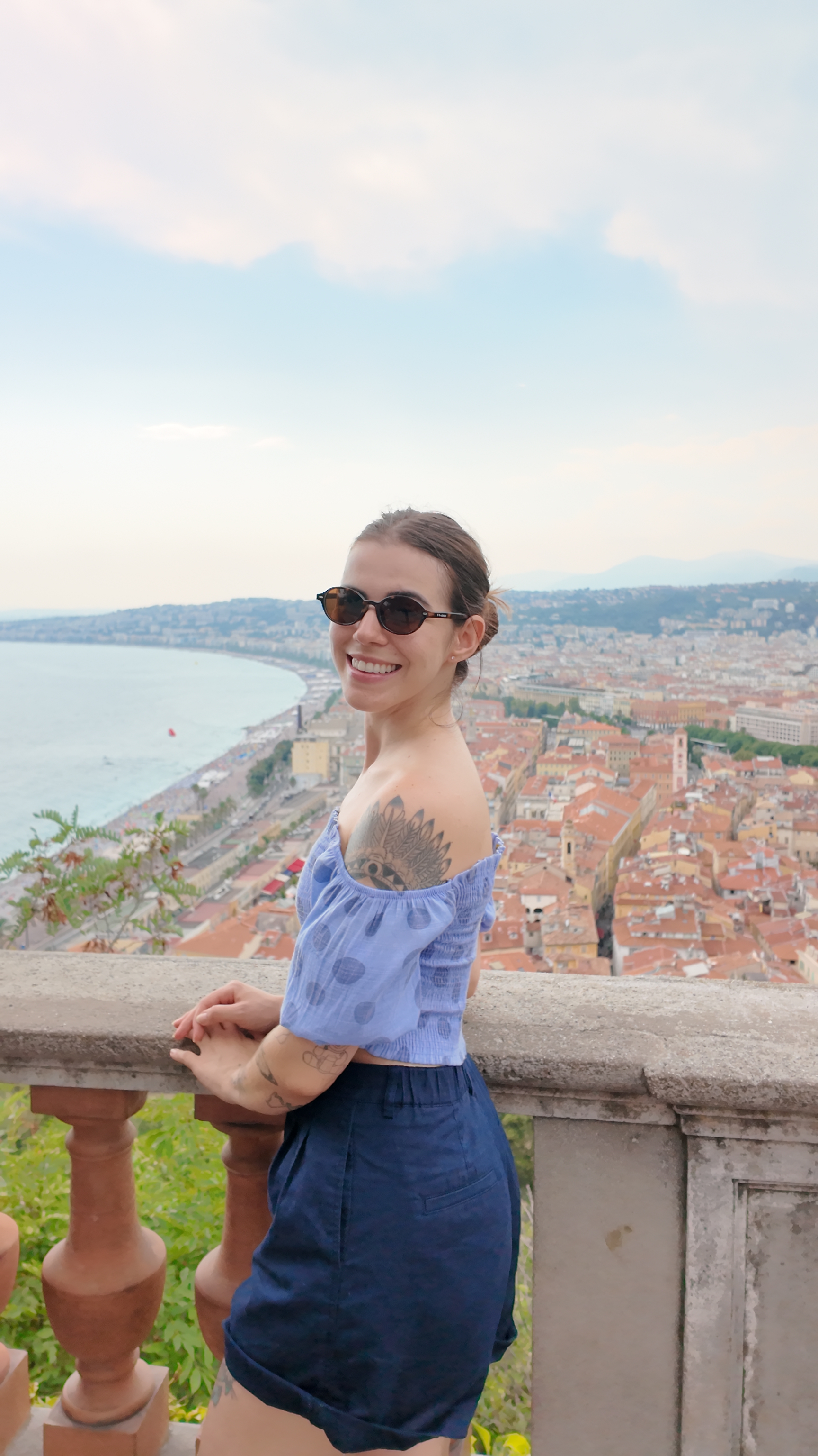 Young woman posing from above with scenic waterfront view of Nice and turquoise Mediterranean Sea
