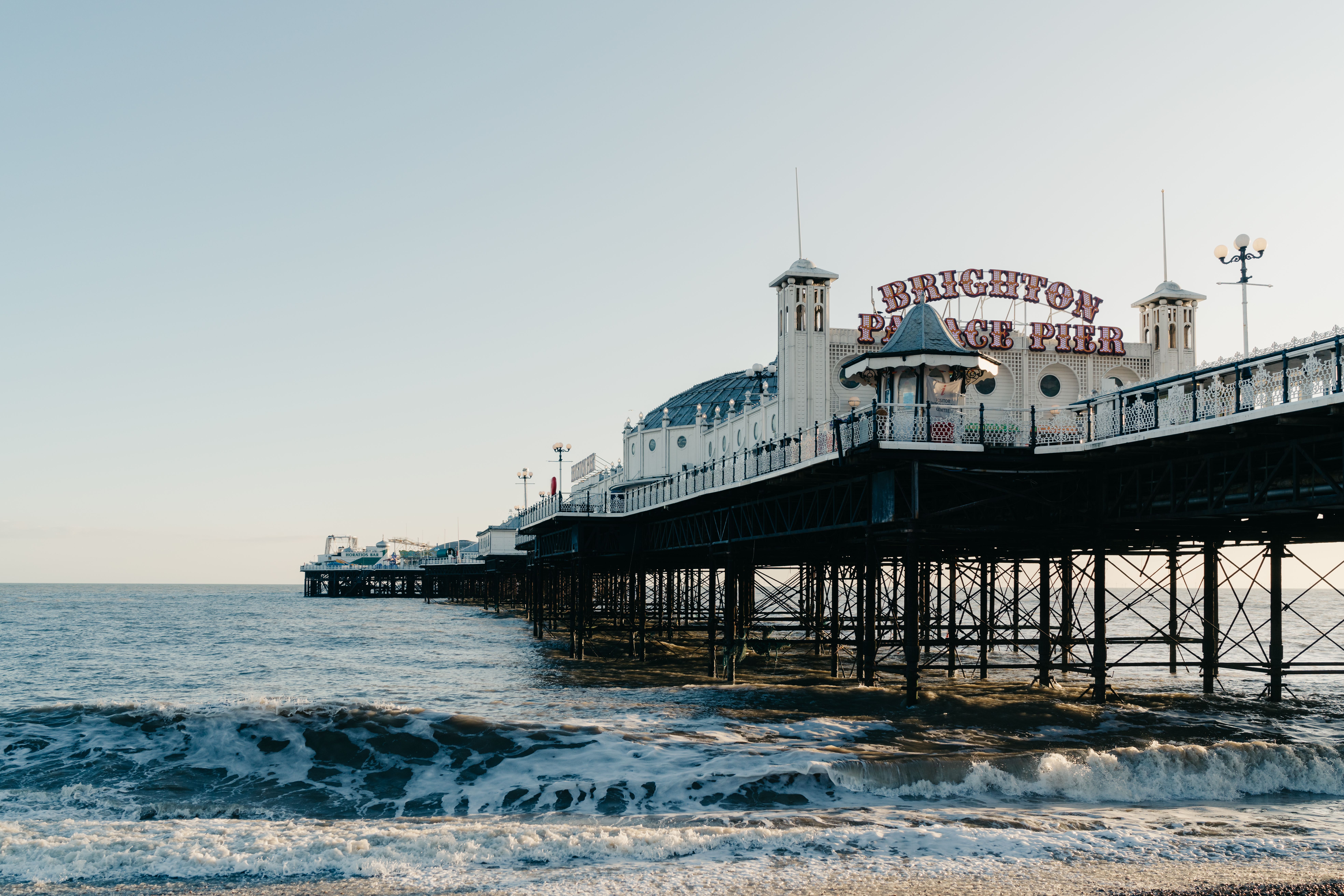 Brighton Pier with amusement rides and colorful lights extending into the English Channel, United Kingdom