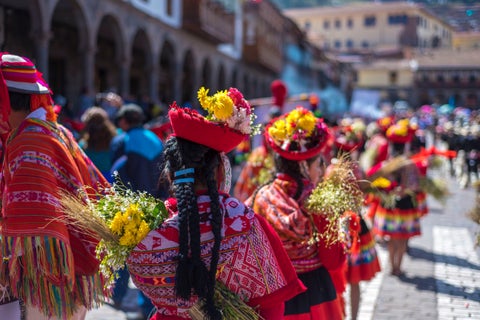 People dressed in red traditional costumes participating in the Inti Raymi festival in Cusco, Peru