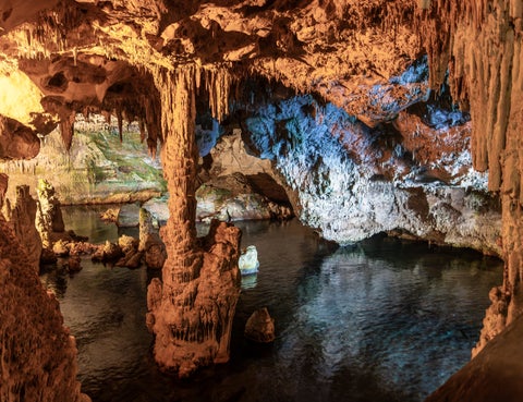 Stone cave in Alghero, Italy, featuring rugged rock formations and natural textures