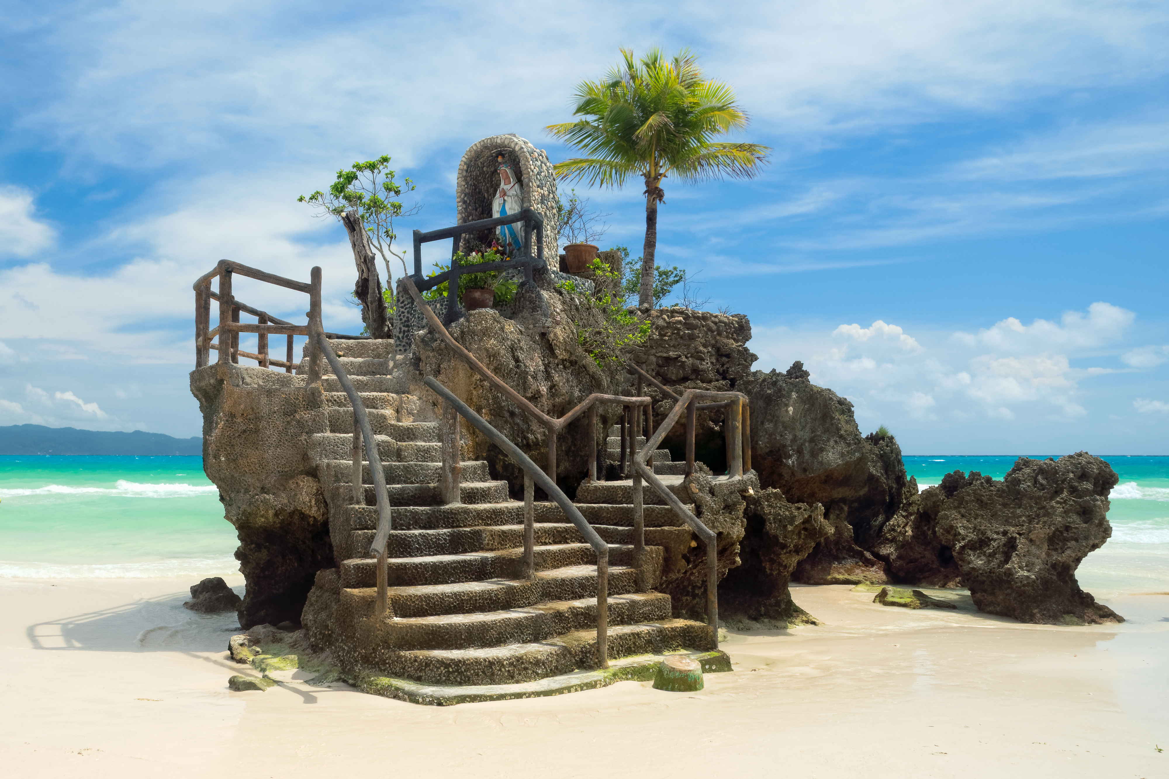 Willy’s Rock in Boracay, Philippines, featuring a statue of the Virgin Mary atop a volcanic formation on White Beach