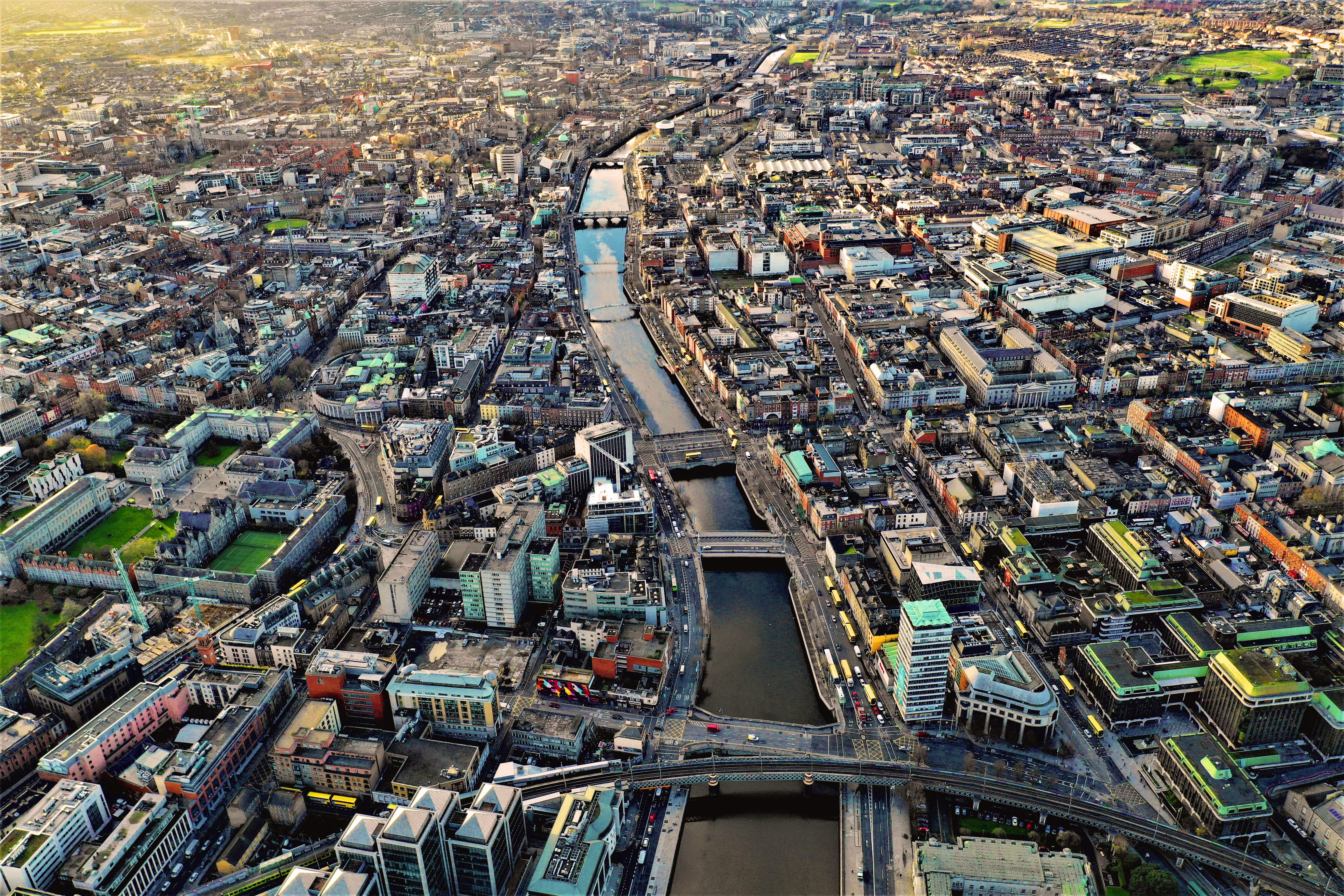 Aerial view of Dublin city featuring River Liffey winding through the city, historic buildings, and modern structures