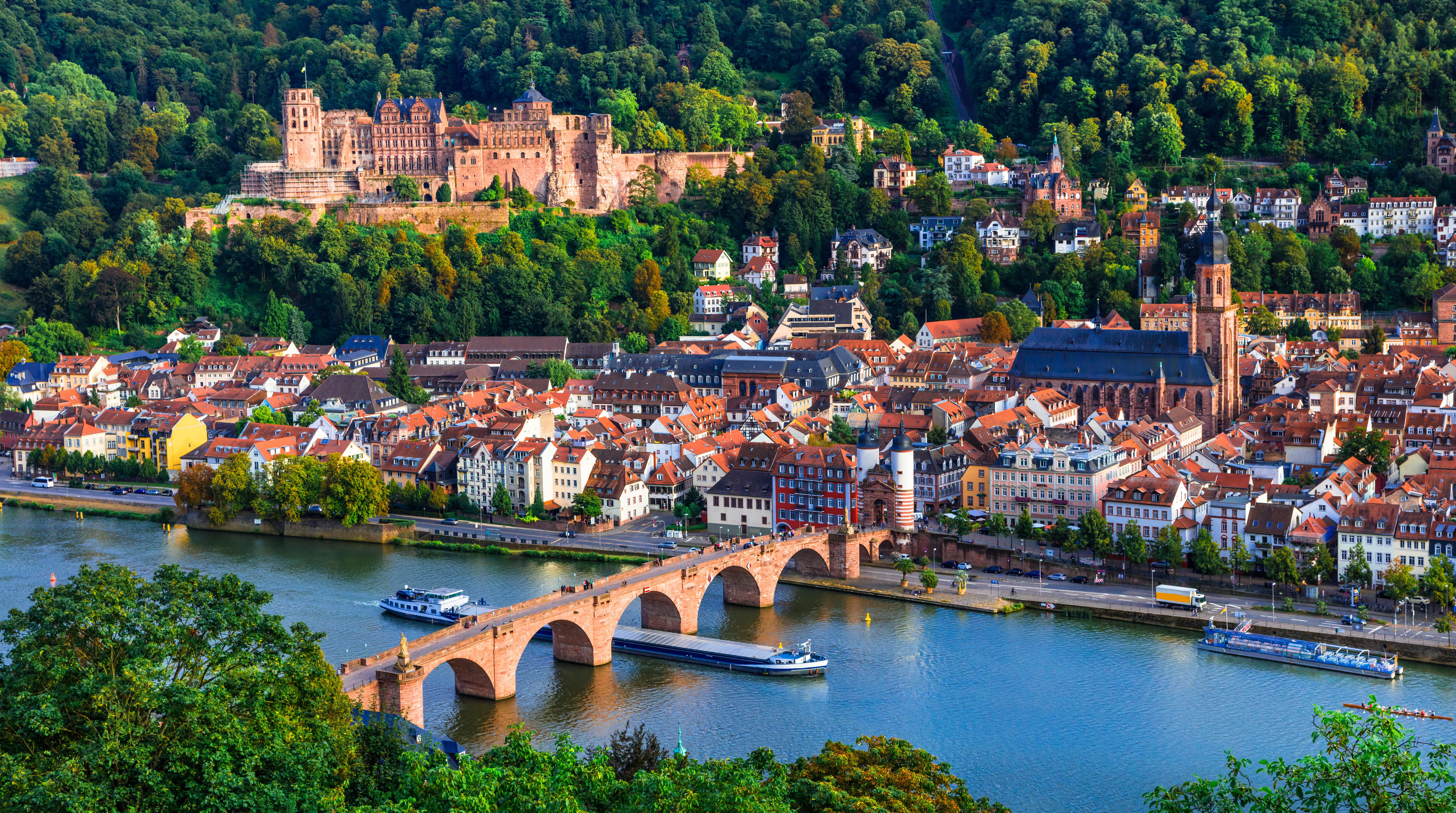 Heidelberg's Old Town with its medieval streets, the historic Heidelberg Castle perched on the hillside, and the iconic Old Bridge spanning the Neckar River