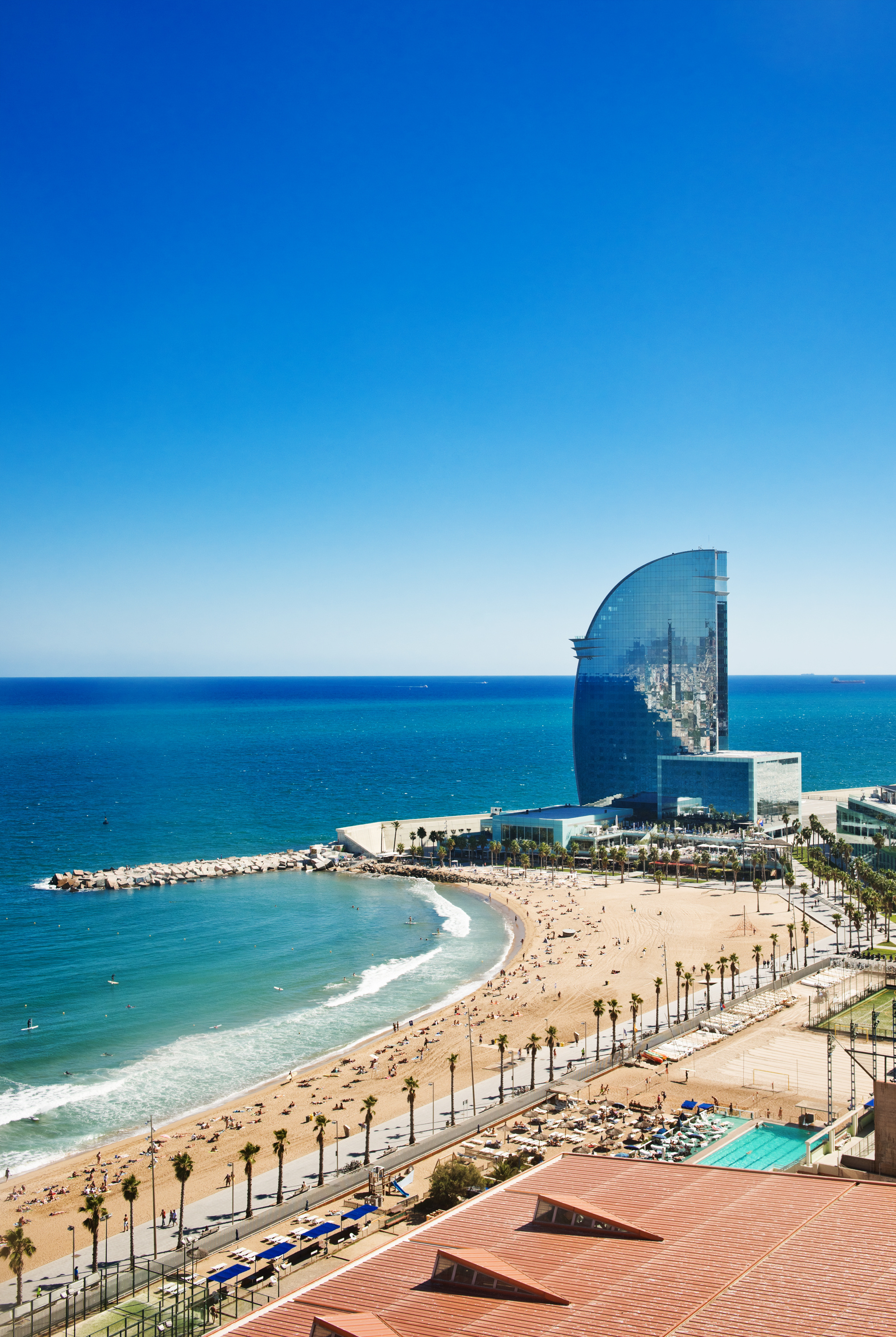 Aerial view of the Harbor district in Barcelona, Spain, featuring docks, ships, waterfront buildings, and the Mediterranean Sea