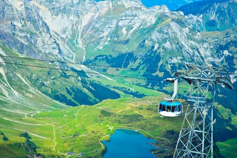 Cable car in Engelberg, Switzerland, ascending with scenic alpine mountains and rugged peaks in the background