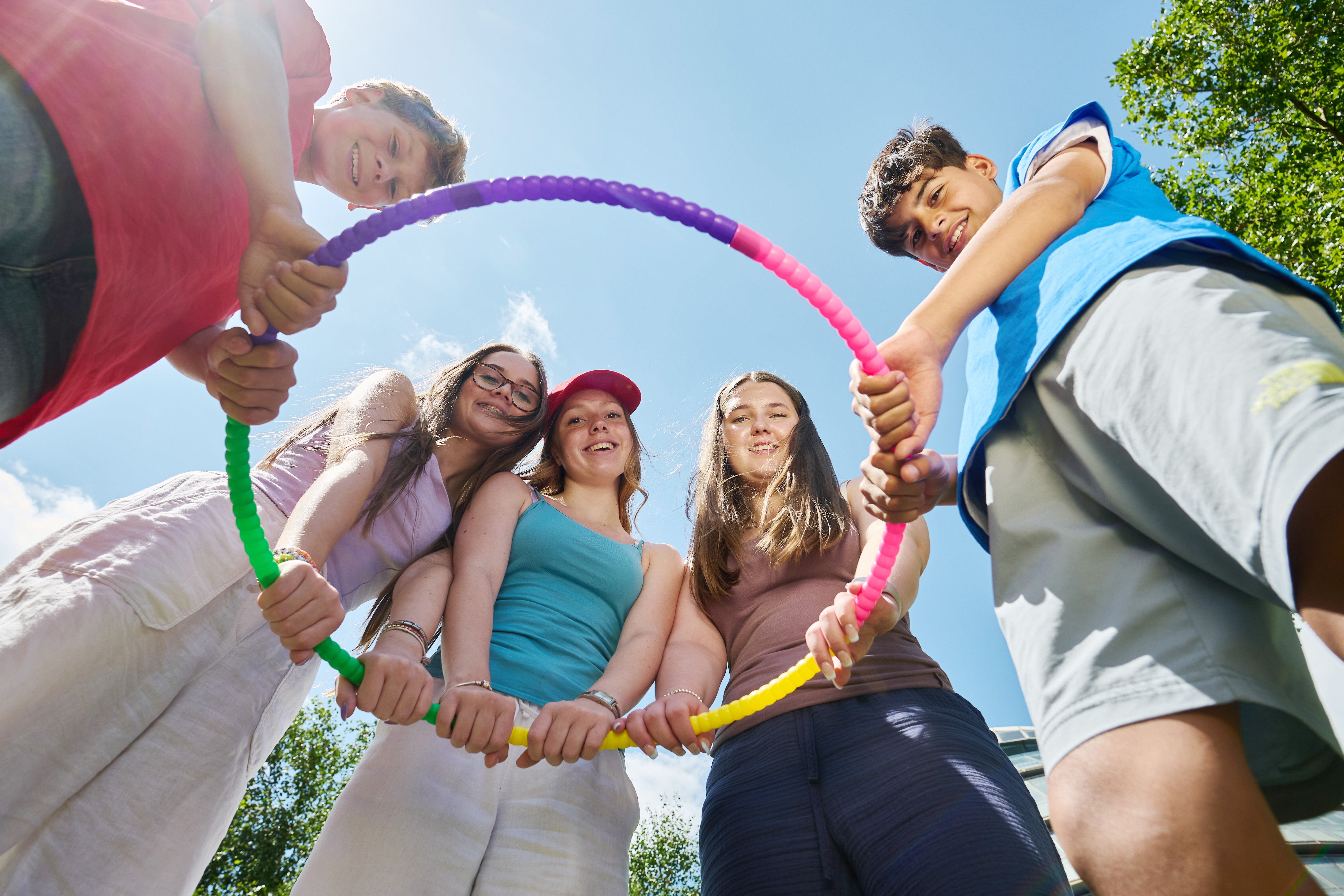 Group of Alpadia teen students holding hula hoop in London park