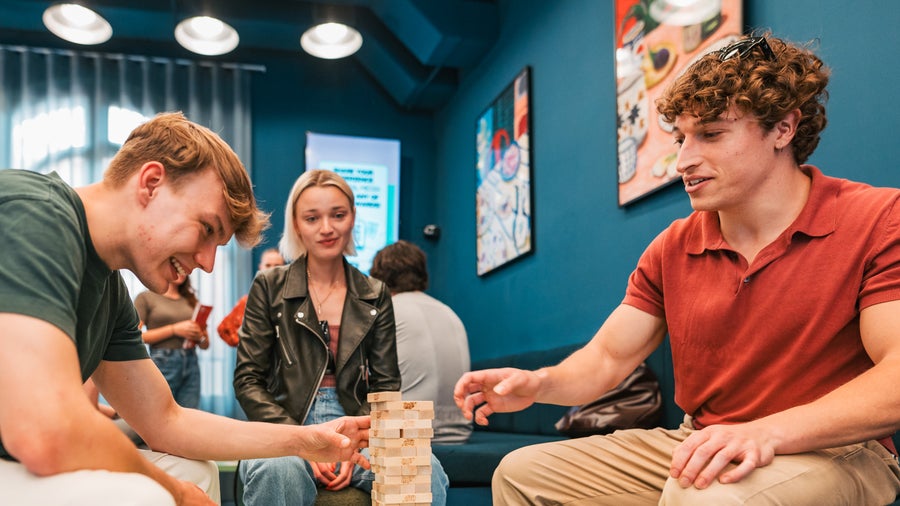 Three students playing Jenga in the common room