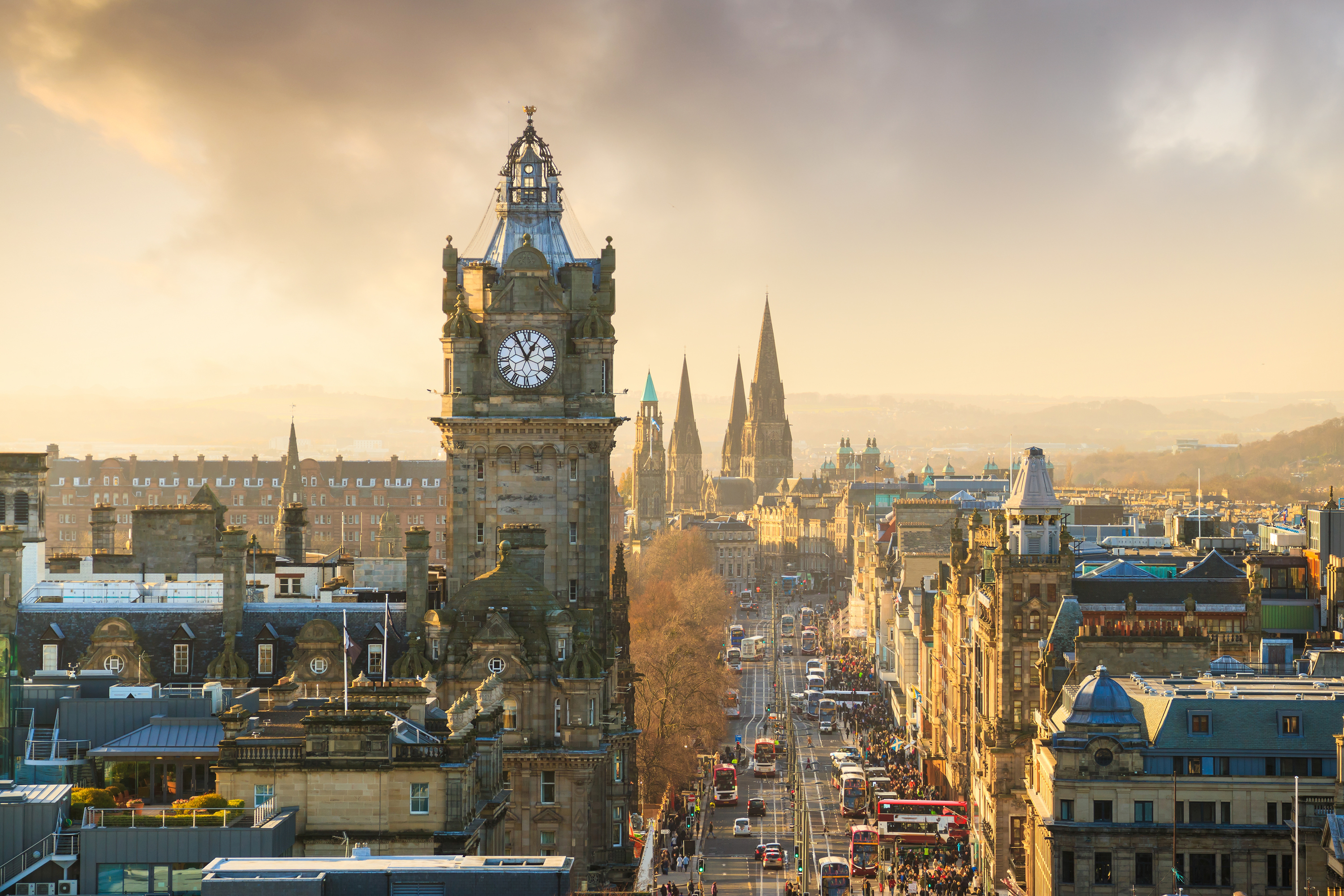 Sunset view of Edinburgh skyline with historic buildings and warm sky colors