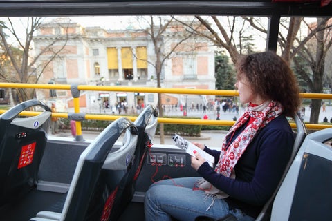 Tourist riding a tour bus passing historic landmarks in Madrid, Spain
