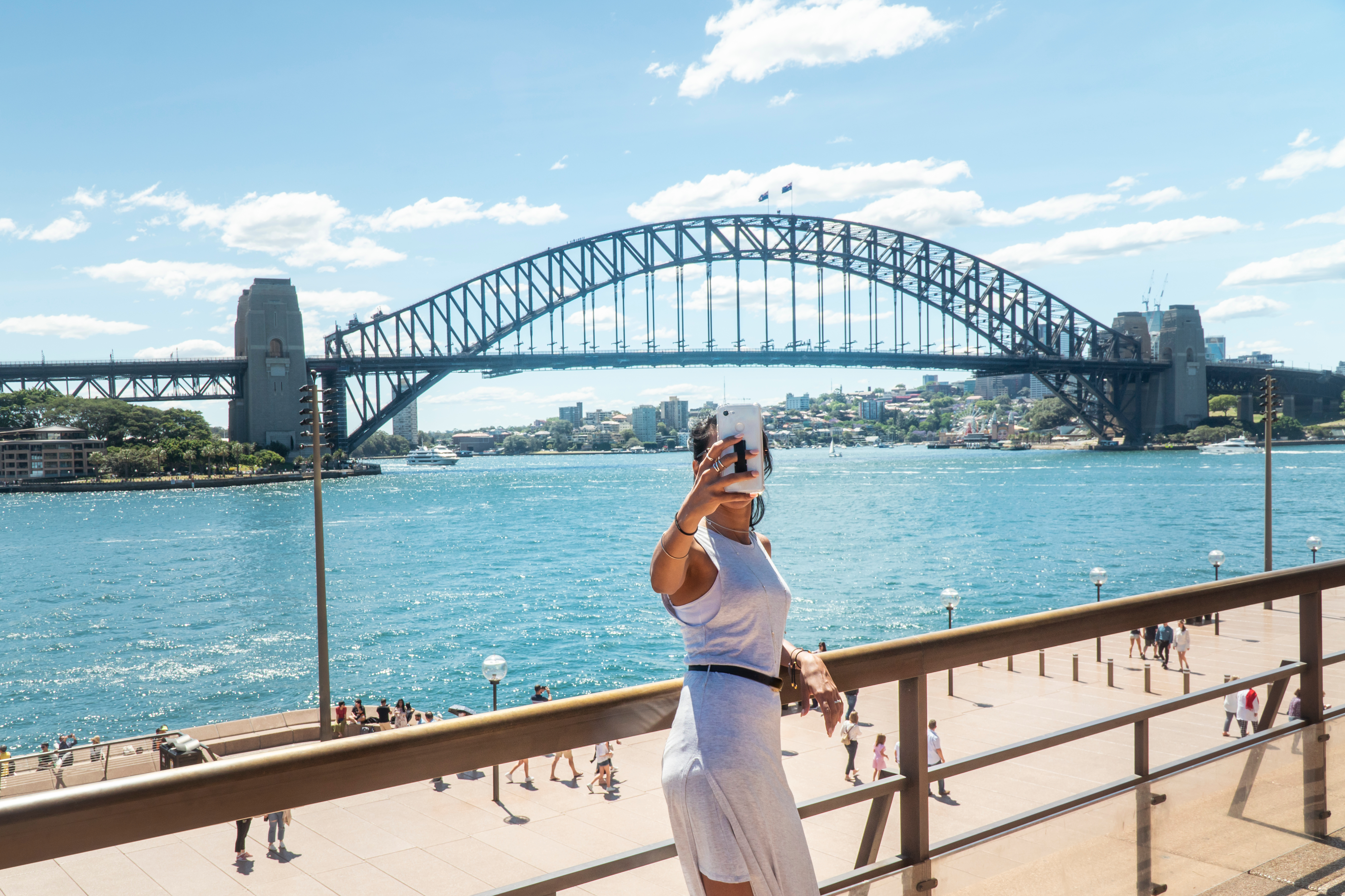 Tourist taking a selfie with the Harbour Bridge at the background in Sydney, Australia