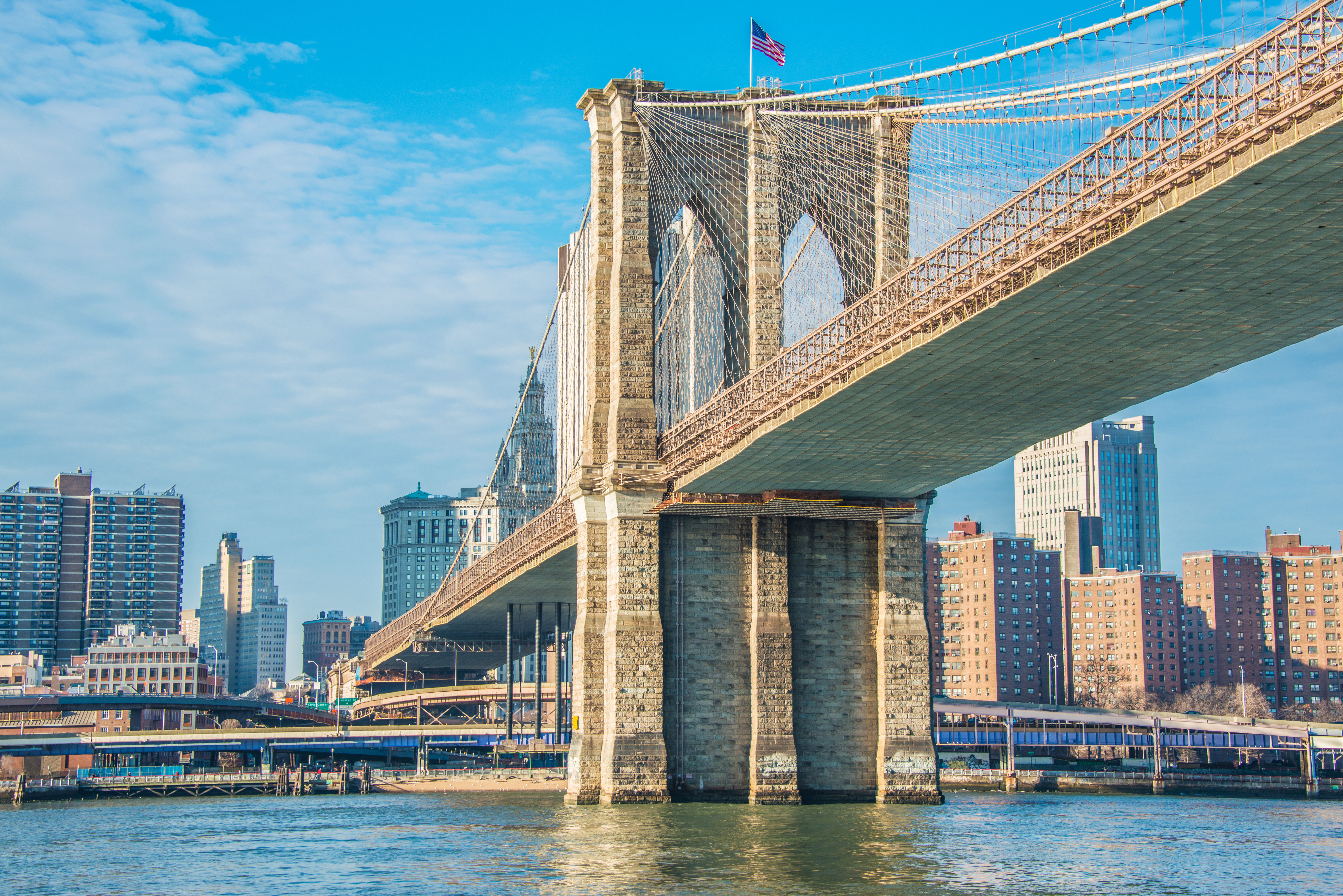 Brooklyn Bridge viewed from below over the river in Manhattan, New York City