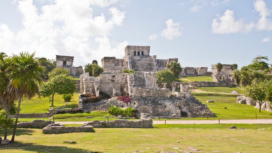 Chichén Itzá surrounded by lush greenery and ancient Maya ruins near Playa Del Carmen, Mexico