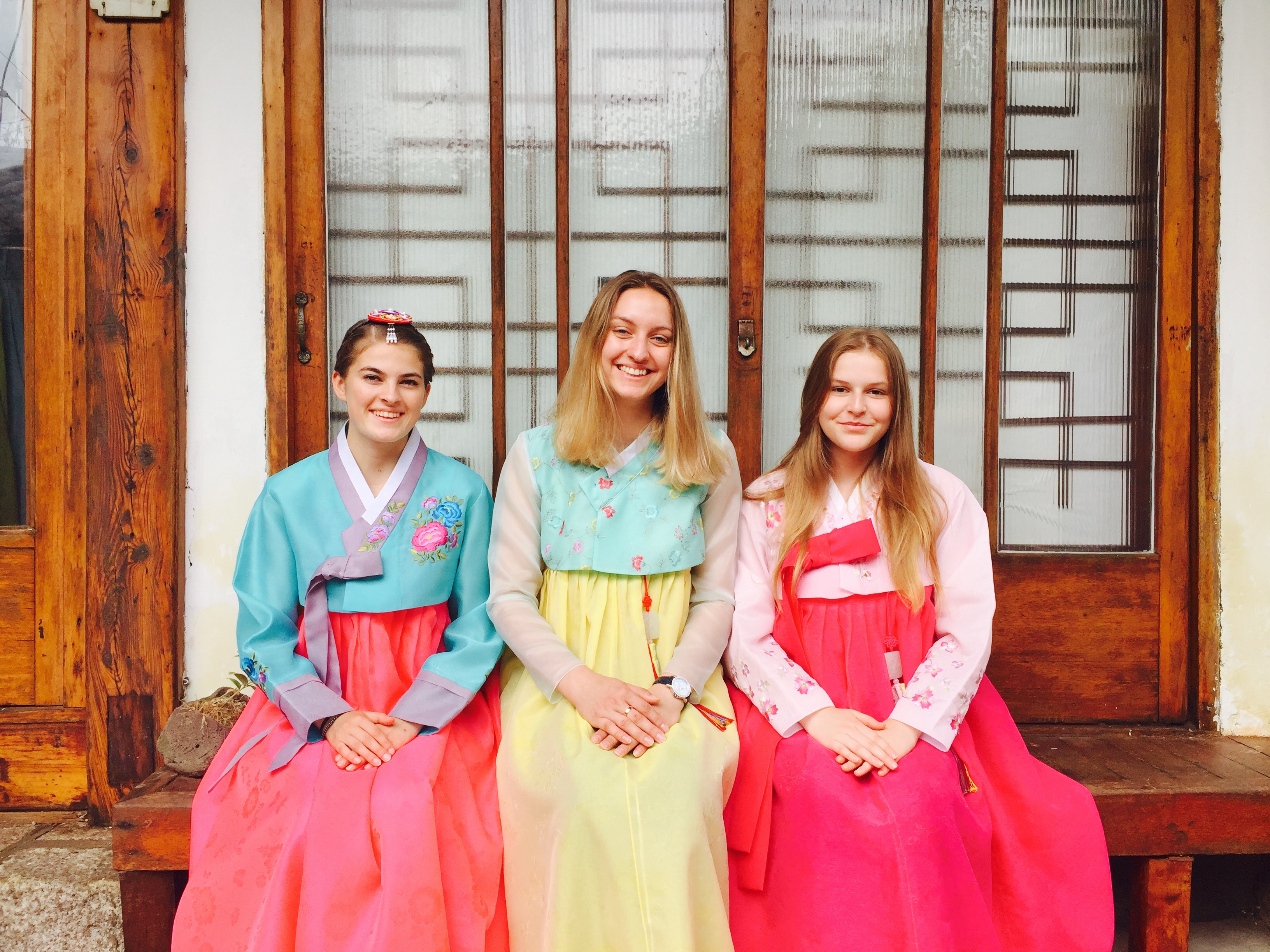 Three students wearing traditional costumes