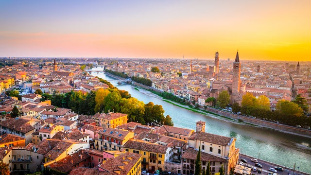 Aerial view of Verona, Italy, featuring the Adige River and a historic bridge crossing it