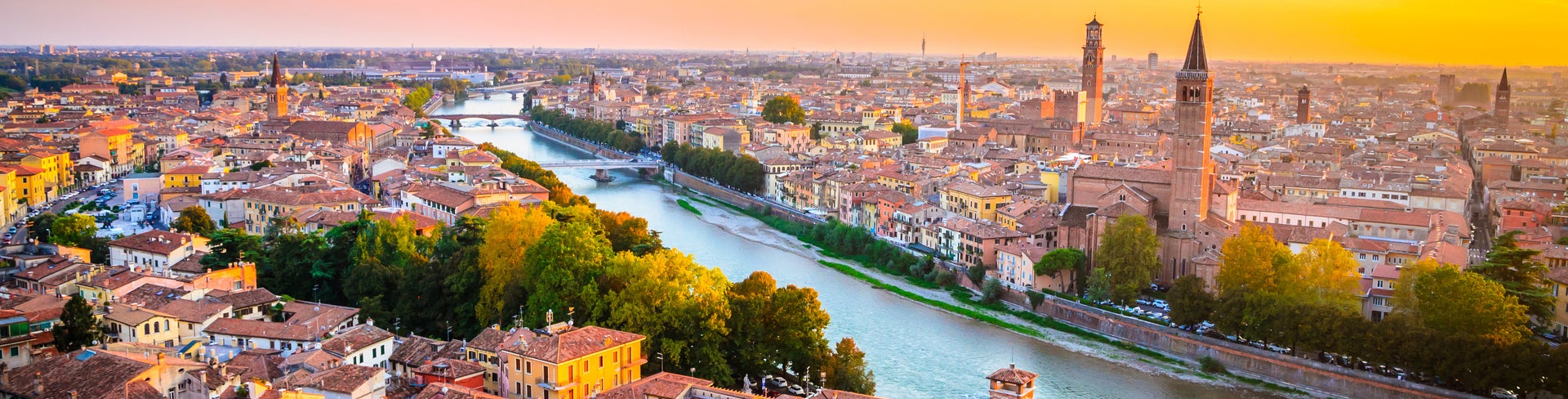 Aerial view of Verona, Italy, featuring the Adige River and a historic bridge crossing it