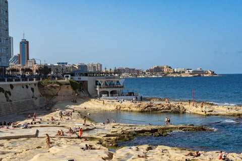 Natural pool along the rocky coast of Salina Bay, Malta, with clear turquoise water and coastal rock formations
