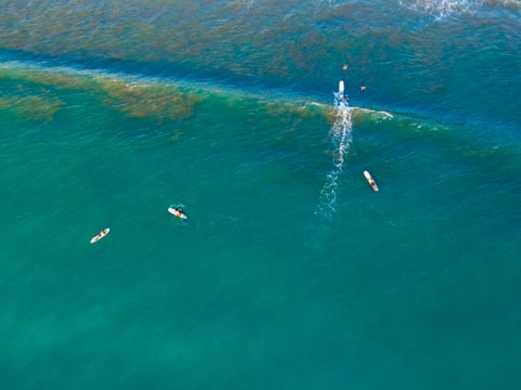 Aerial view of the ocean with surfboarders in Playa Jacó, Costa Rica